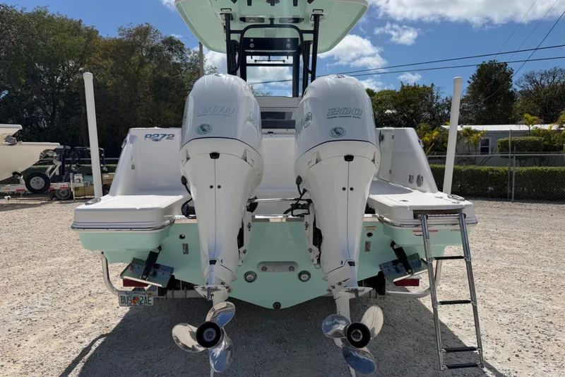 Slide: The Image of 2020 Robalo R272 Center Console boat with dual outboard engines, parked outdoors. - 2