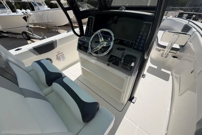 Slide: The Image of 2020 Robalo R272 Center Console boat interior with steering wheel and seating. - 6