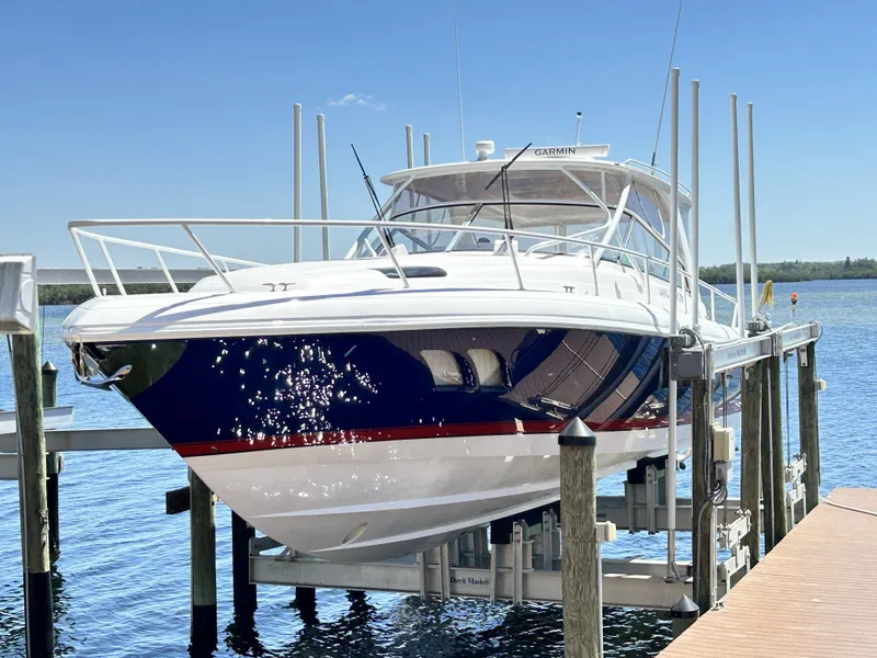 Slide: The Image of 2018 Intrepid 475 Sport Yacht on a boat lift by the water. - 10