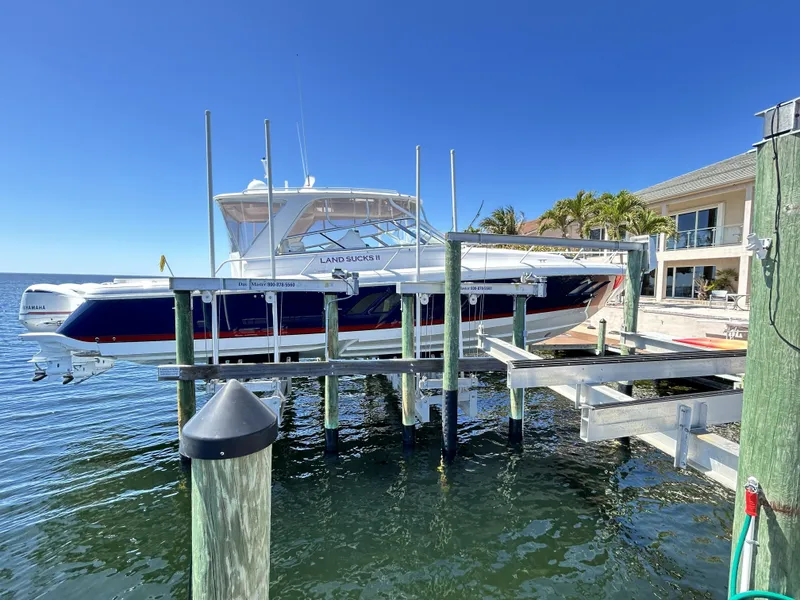 Slide: The Image of 2018 Intrepid 475 Sport Yacht on a boat lift by the water. - 4