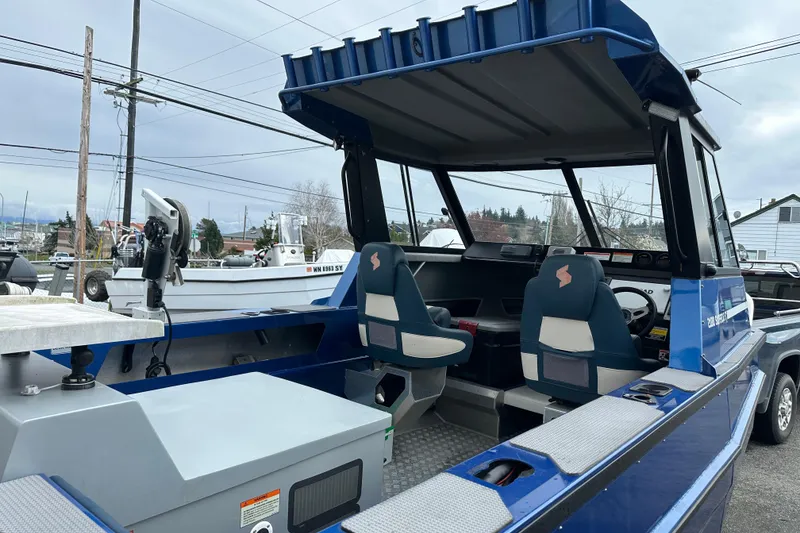 Slide: The Image of 2017 Stabicraft 2100 Supercab boat interior with seating and controls, parked outdoors. - 11