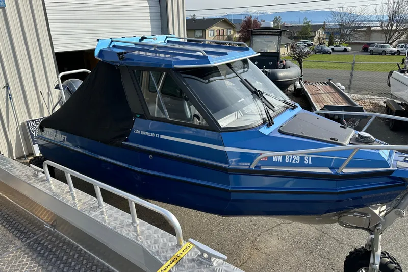 Slide: The Image of 2017 Stabicraft 2100 Supercab boat in blue, parked outside a garage. - 13