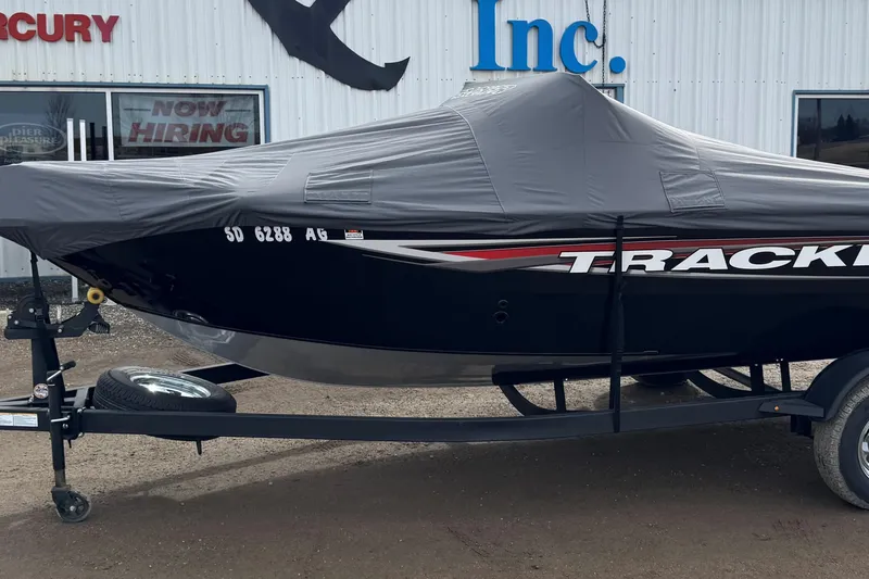Slide: The Image of 2025 Tracker Pro Guide V-175 WT boat covered, parked on trailer outside dealership. - 10