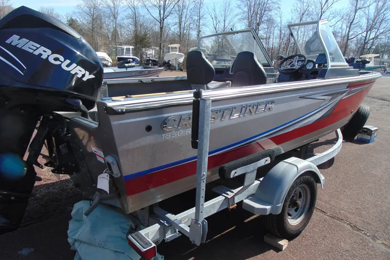 Slide: The Image of 2018 Crestliner 1850 Raptor WT boat on trailer with Mercury engine, parked outdoors. - 3