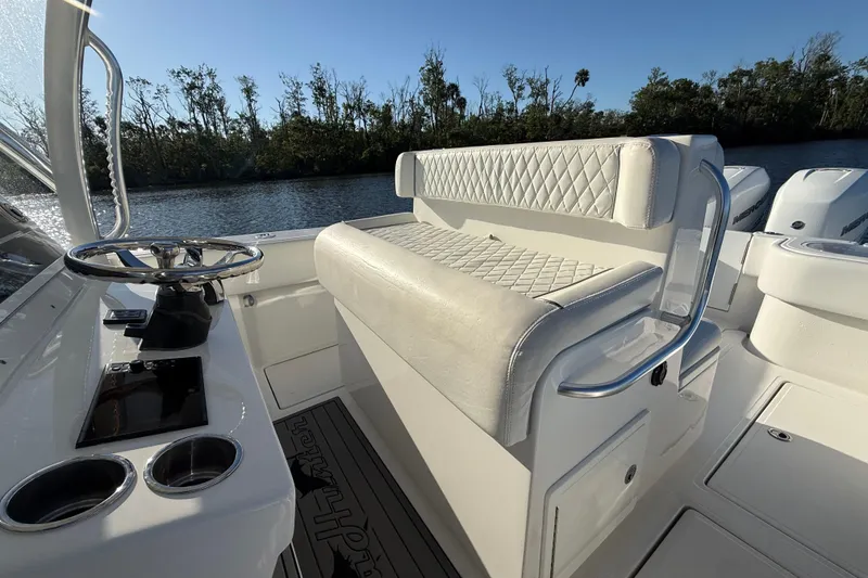 Slide: The Image of 2020 Sea Hunter 31 Tournament boat interior with steering wheel and cushioned seating. - 14