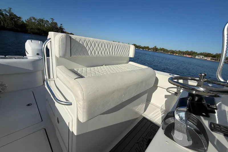 Slide: The Image of 2020 Sea Hunter 31 Tournament boat with white seating and steering wheel on a sunny day. - 15