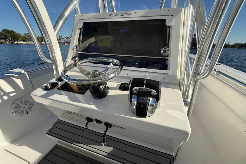 Slide: The Image of 2020 Sea Hunter 31 Tournament boat console with steering wheel and controls on a sunny day. - 16