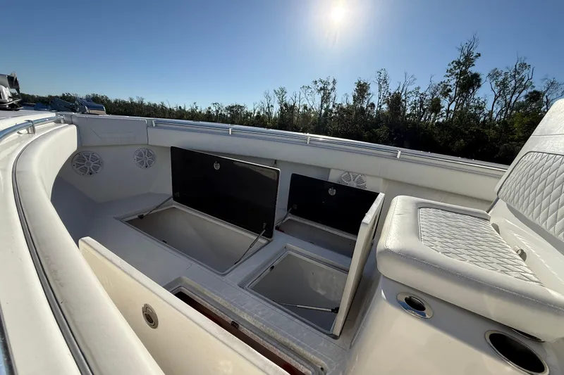 Slide: The Image of 2020 Sea Hunter 31 Tournament boat interior with open storage compartments under clear sky. - 25