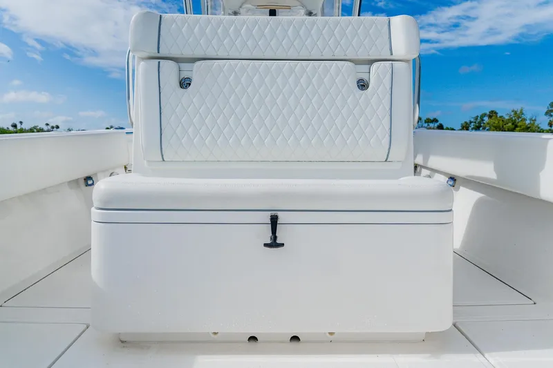 Slide: The Image of 2020 SeaHunter 31 Tournament boat with white cushioned seating and storage, under a clear blue sky. - 47