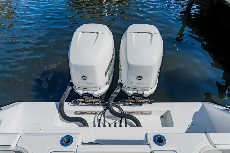 Slide: The Image of Twin outboard engines on a 2020 SeaHunter 31 Tournament boat, docked on calm water. - 56