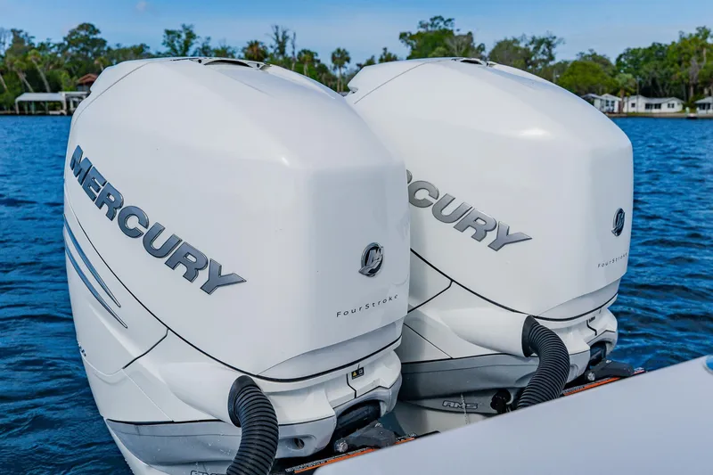 Slide: The Image of Twin Mercury outboard engines on a 2020 SeaHunter 31 Tournament boat, on a serene lake. - 57