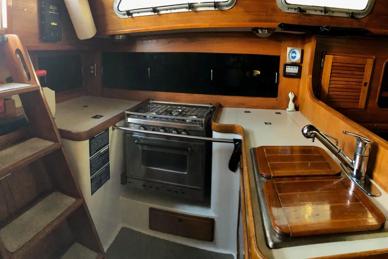 Slide: The Image of Interior of 1988 Freedom 36 sailboat kitchen with stove, sink, and wooden cabinetry. - 11