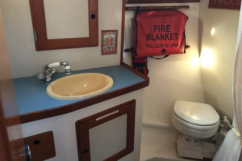Slide: The Image of Compact bathroom in a 1988 Freedom 36 yacht with sink, toilet, and fire blanket. - 13