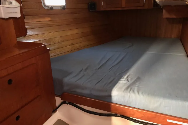 Slide: The Image of Cozy cabin interior of 1988 Freedom 36 sailboat with wooden paneling and bed. - 15