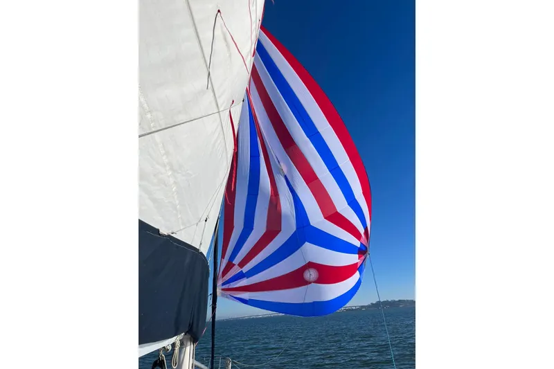 Slide: The Image of Sailboat with colorful spinnaker, Freedom 36 model, 1988, on open water. - 7