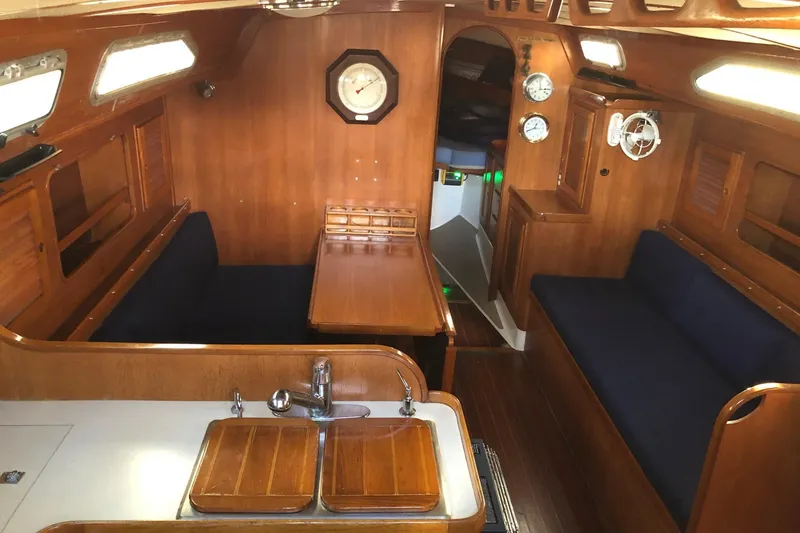 Slide: The Image of Interior of 1988 Freedom 36 sailboat with wooden furnishings and blue seating. - 8