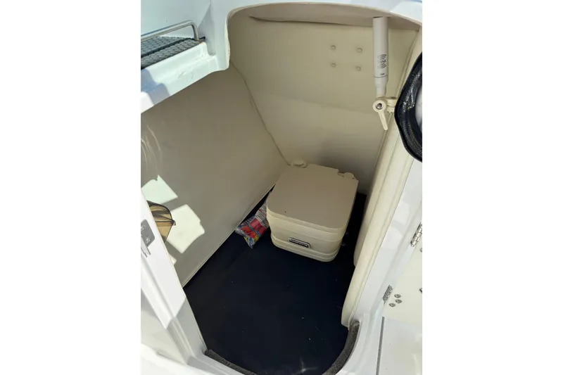 Slide: The Image of 2005 Cobalt 240 boat interior with portable toilet and storage space. - 12