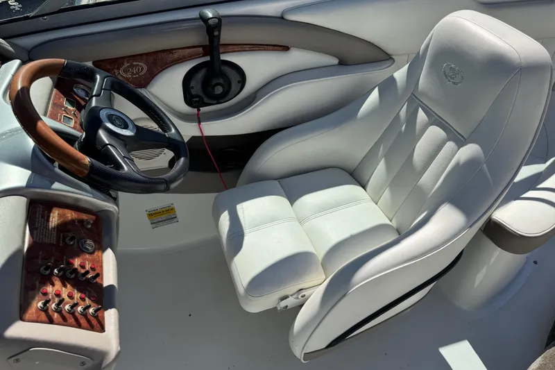 Slide: The Image of 2005 Cobalt 240 boat interior with white leather seat and wooden dashboard. - 14