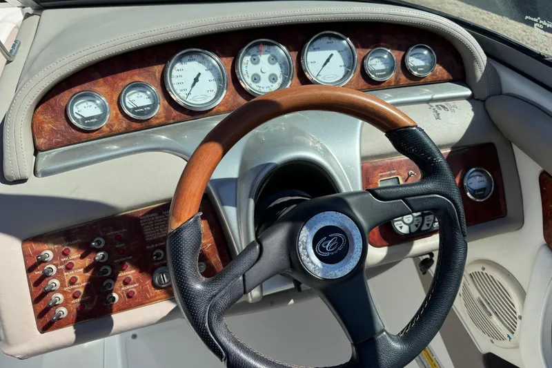 Slide: The Image of Steering wheel and dashboard of a 2005 Cobalt 240 boat with wood accents. - 15