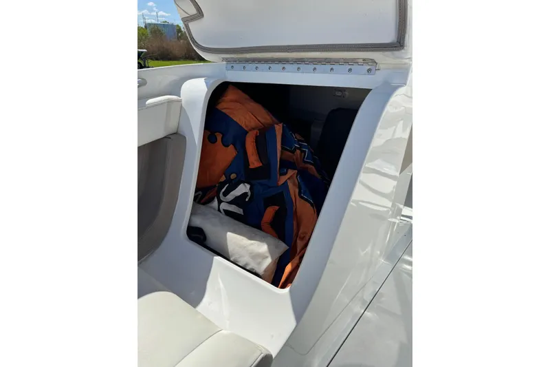 Slide: The Image of Open storage compartment in 2005 Cobalt 240 boat with life jackets inside. - 20