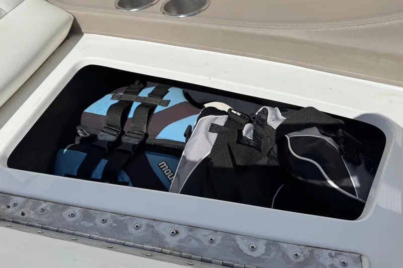 Slide: The Image of Storage compartment in a 2005 Cobalt 240 boat with life jackets inside. - 22