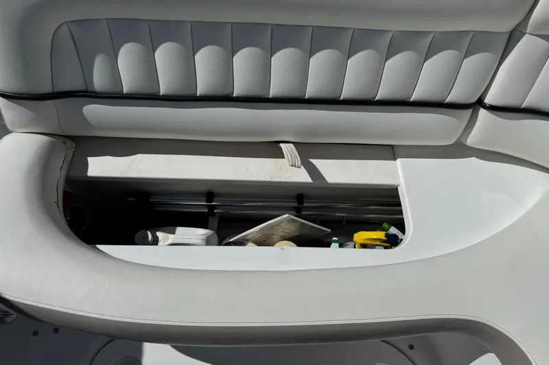 Slide: The Image of Open storage compartment in a 2005 Cobalt 240 boat with various items inside. - 5