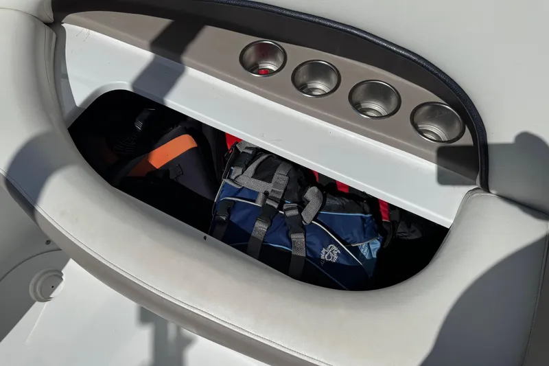 Slide: The Image of Storage compartment in a 2005 Cobalt 240 boat with bags and cup holders. - 8