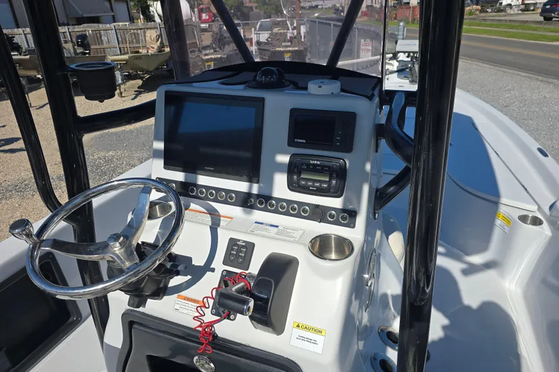 Slide: The Image of 2021 Blue Wave 2400 PureBay boat console with steering wheel and navigation controls. - 14