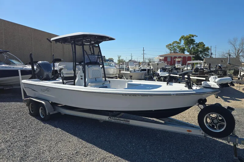 Slide: The Image of 2021 Blue Wave 2400 PureBay boat on trailer, parked outdoors under clear blue sky. - 3
