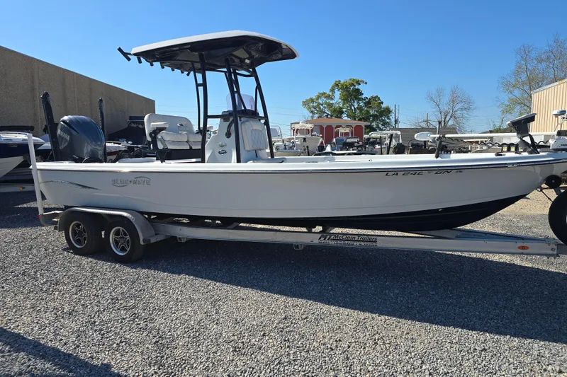 Slide: The Image of 2021 Blue Wave 2400 PureBay boat on trailer, parked outdoors on gravel. - 4