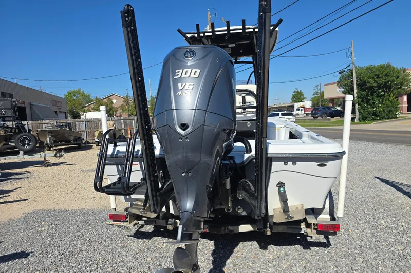 Slide: The Image of 2021 Blue Wave 2400 PureBay boat with powerful 300 V6 engine, parked on gravel. - 6