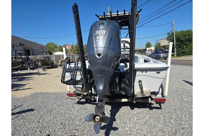 Slide: The Image of 2021 Blue Wave 2400 PureBay boat with powerful 300 V6 engine, parked on gravel. - 7