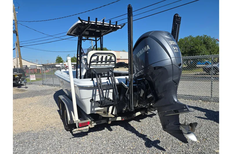 Slide: The Image of 2021 Blue Wave 2400 PureBay boat with Yamaha 300 V6 engine, parked on gravel. - 8