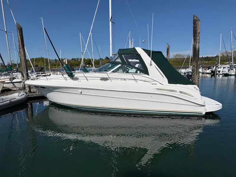 The Image of 1999 Sea Ray 340 Sundancer yacht docked in a marina under clear blue skies. - 0