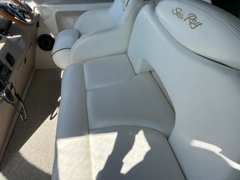 Slide: The Image of 1999 Sea Ray 340 Sundancer interior with white leather seating and steering wheel. - 13