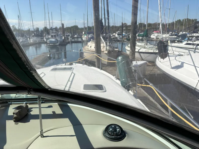 Slide: The Image of 1999 Sea Ray 340 Sundancer docked in a marina, surrounded by sailboats. - 21