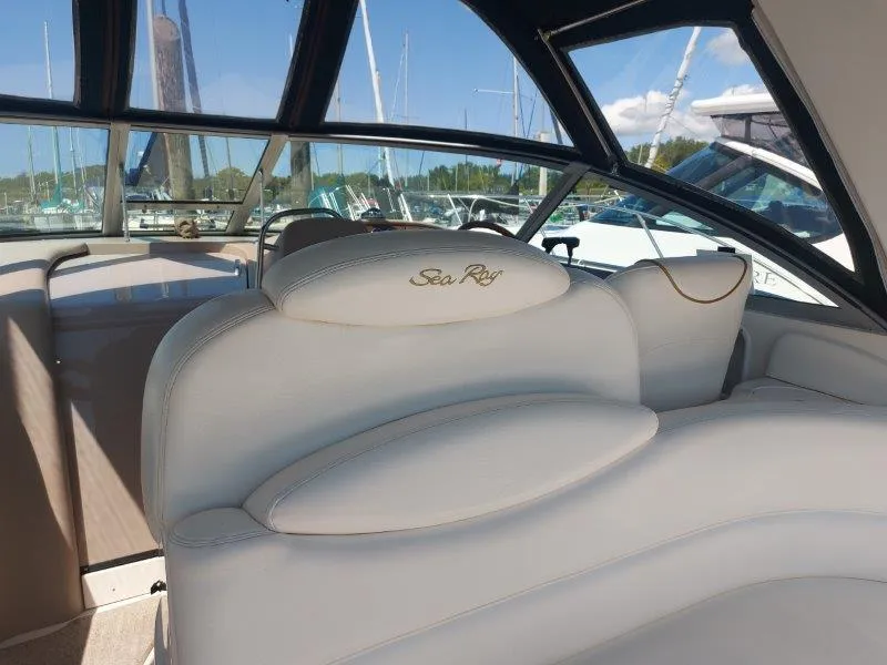 Slide: The Image of 1999 Sea Ray 340 Sundancer interior with white seating and marina view. - 32