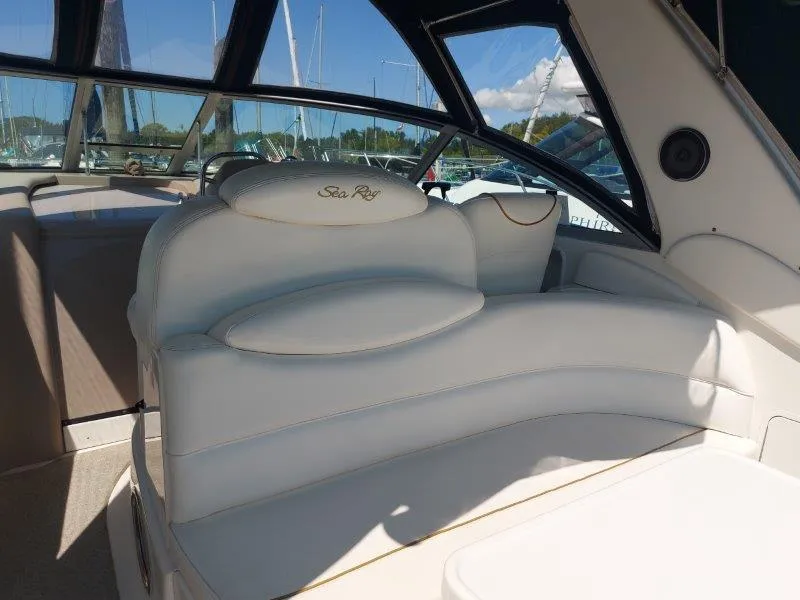 Slide: The Image of 1999 Sea Ray 340 Sundancer interior with white seating and marina view. - 40