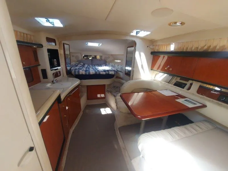 Slide: The Image of Interior of 1999 Sea Ray 340 Sundancer yacht, featuring cozy cabin and dining area. - 43
