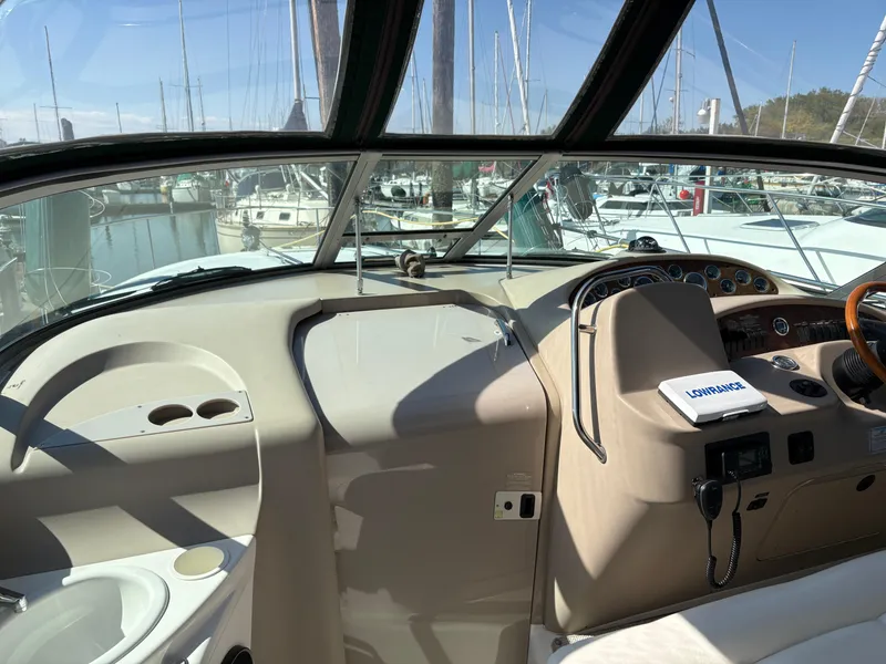 Slide: The Image of 1999 Sea Ray 340 Sundancer cockpit with steering wheel, navigation equipment, and marina view. - 9
