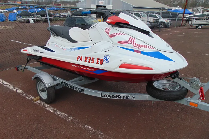 The Image of 2022 Yamaha WaveRunner VX Deluxe on trailer, white and red design, parked outdoors. - 1