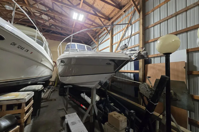 Slide: The Image of 2008 Regal 3060 Window Express boat stored indoors, surrounded by wooden beams and equipment. - 2