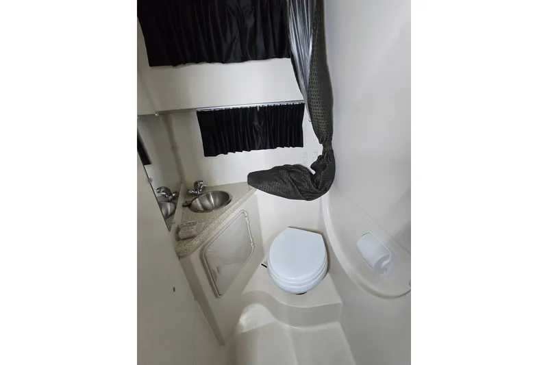 Slide: The Image of Compact bathroom in 2008 Regal 3060 Window Express boat, featuring sink and toilet. - 29