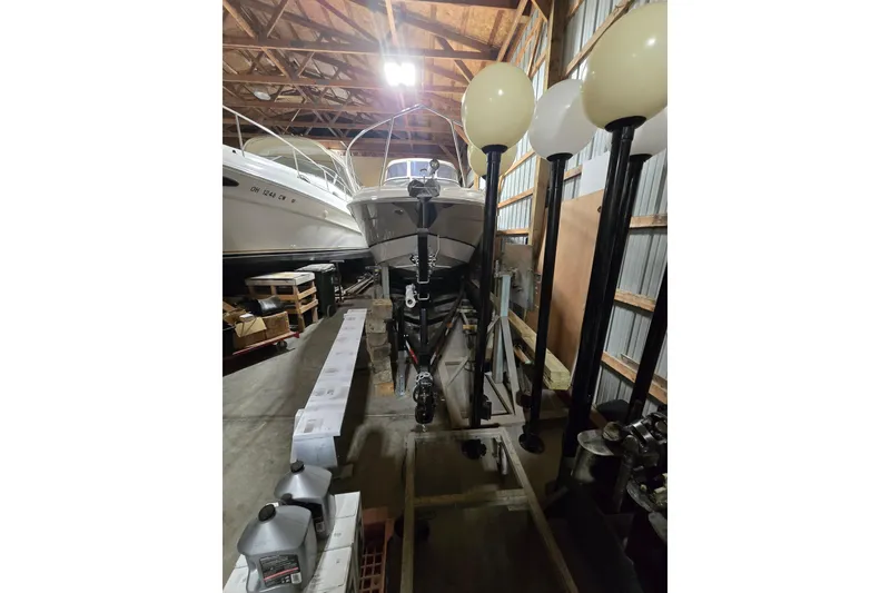 Slide: The Image of 2008 Regal 3060 Window Express boat stored indoors with equipment nearby. - 3