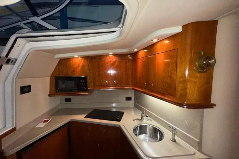 Slide: The Image of 2004 Cruisers Yachts 340 Express interior kitchen with wood cabinets and modern appliances. - 18