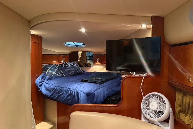 Slide: The Image of Luxurious cabin interior of 2004 Cruisers Yachts 340 Express with bed, TV, and fan. - 2