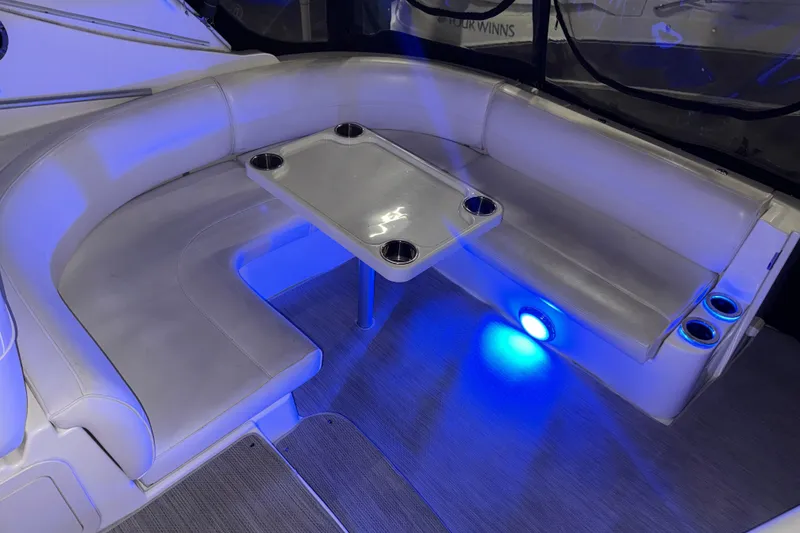 Slide: The Image of 2004 Cruisers Yachts 340 Express interior with blue LED lighting and cushioned seating. - 30