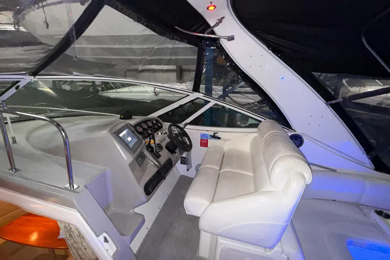 Slide: The Image of Interior cockpit of 2004 Cruisers Yachts 340 Express with white seating and control panel. - 34