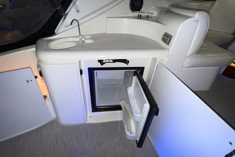 Slide: The Image of 2004 Cruisers Yachts 340 Express interior with open mini fridge and sink. - 36