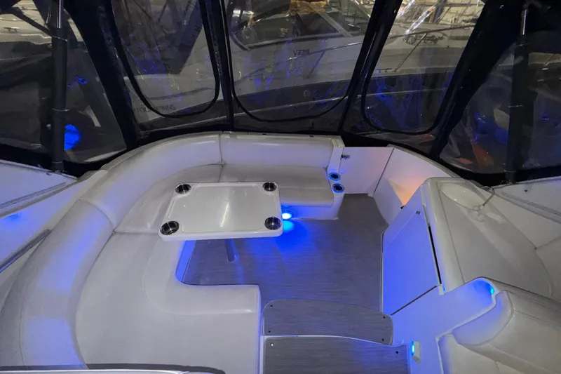 Slide: The Image of 2004 Cruisers Yachts 340 Express interior with seating and ambient blue lighting. - 38